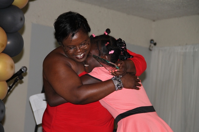 Ms. Husaene Martin gets a heart-warming hug from Junior Minister for Youth and Sports in the Nevis Island Administration Hon. Hazel Brandy-Williams before she is presented with an award in the Minister’s name at the Department of Youth and Sports Awards Ceremony and Gala on April 26, 2014 at the Occasions Conference Centre at the Pinney’s Industrial Site